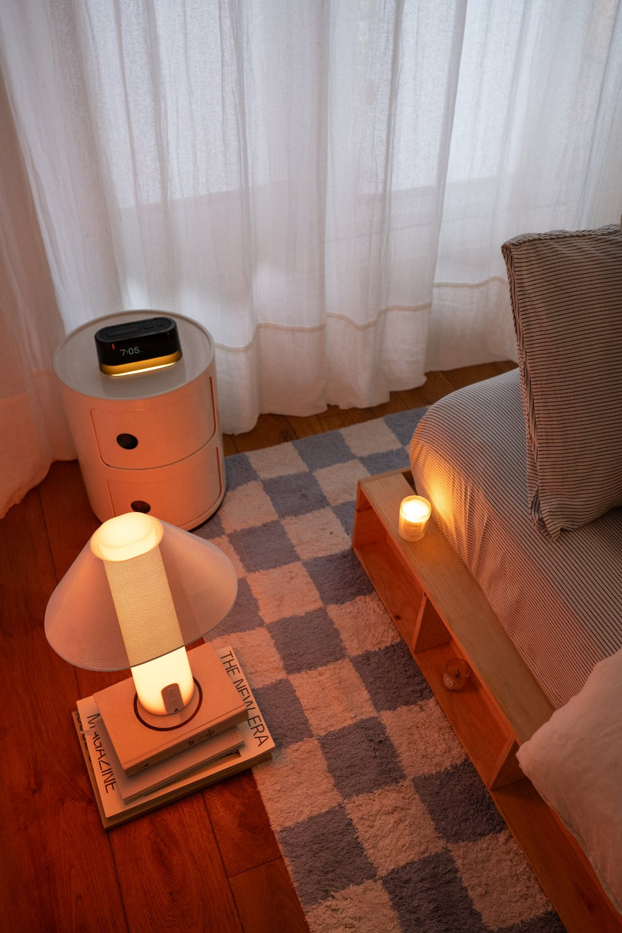 Warm evening bedroom lit by the Loftie Lamp, Clock and a candle