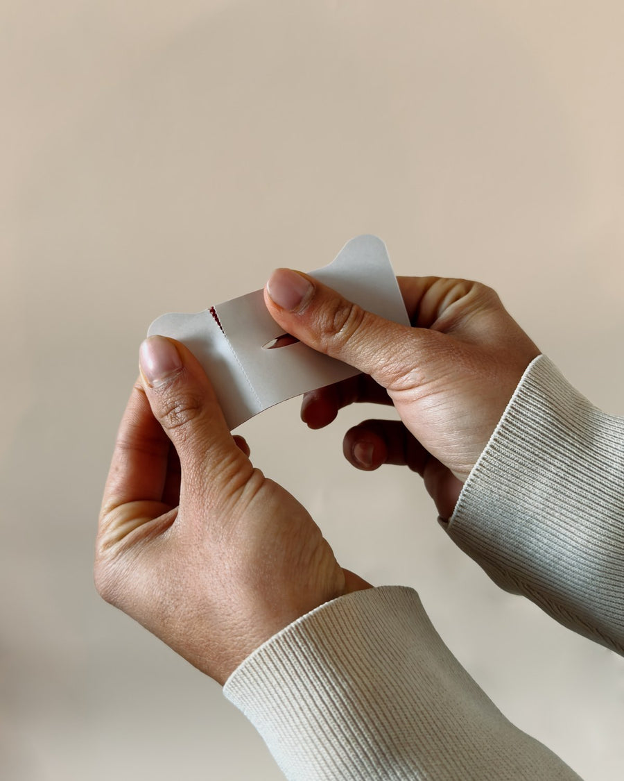 Hands tearing the backing off a mouth tape strip
