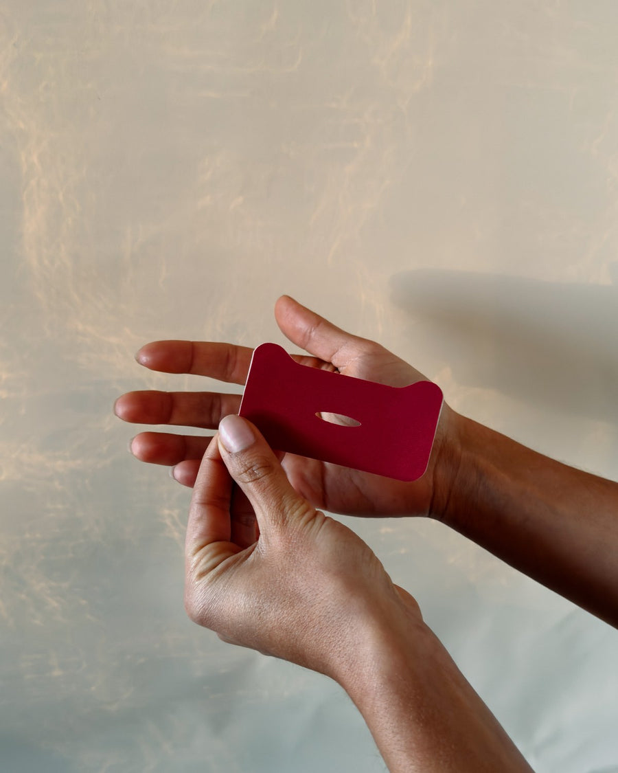 Holding a Bordeaux mouth tape strip by its edges